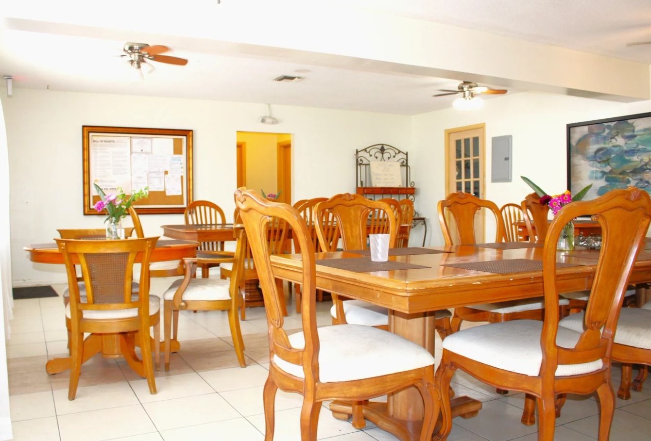 The dining room with polished wooden tables and fresh flowers.